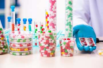 Young male chemist in drug synthesis concept