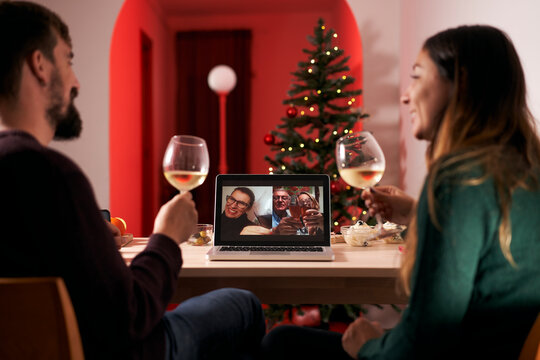 Couple Celebrating Christmas In Quarantine Due To Covid 19, Making A Video Call To Parents And In-laws. New Normal In Times Of Coronavirus.