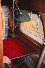 Weaver at loom making silk brocade