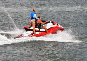 Obraz premium Couple riding on a jetski