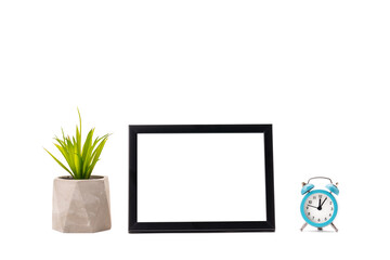planning and schedule mockup. blank frame, blue alarm clock and houseplant isolated on a white background. abstract design composition