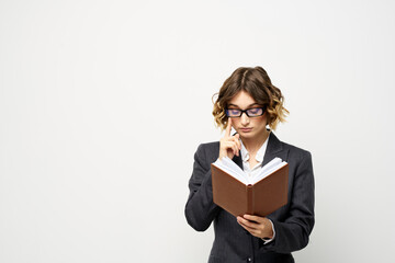 Business woman in a classic suit with a notebook in her hand and glasses on her face Copy Space