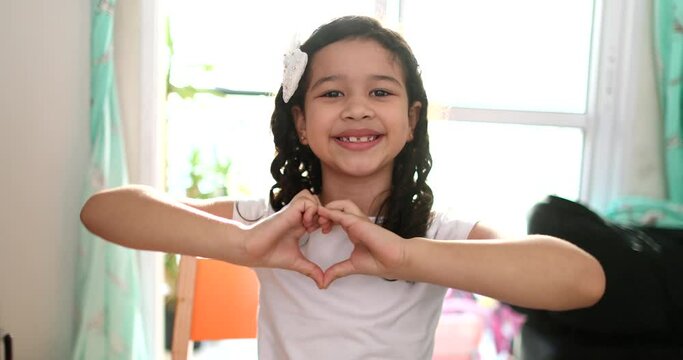 Child making heart symbol with hands