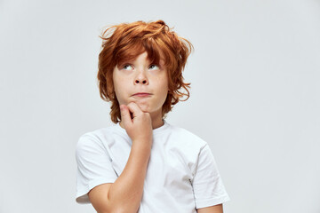 redhead boy close-up looking up hand near chin pensive view  © SHOTPRIME STUDIO