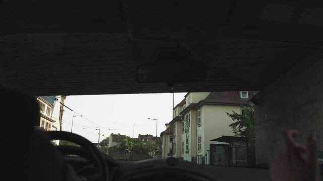 A Man Rides In A Car At Sunset On The Streets Of A Modern City. The Navigator Is Included. Shooting From The Back Seat. Passes Under The Bridge And The Train Goes From Above