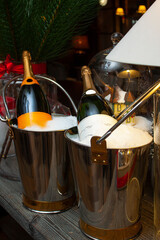Bottles of expensive champagne on frape with ice. Christmas decoration.