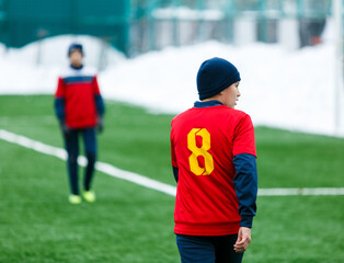 Fototapeta premium Boy in red uniform playing football