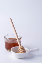 Honey in a clear glass and honey dipper
