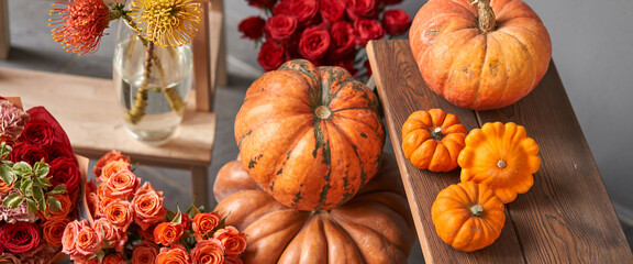 Set of pumpkins and orange and red flowers for Interior decorations. The work of the florist at a flower shop. Fresh cut flower. Autumn mood.