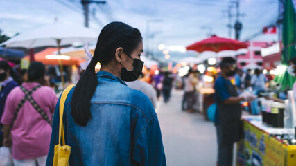 Young Asian woman walking at food street during Asia summer vacation in Thailand.