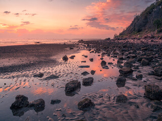 Fototapeta na wymiar Rocky Beach Sunrise with Hill and Reflections