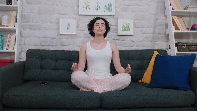 Young woman doing yoga at home. Meditation. Bound angle pose. Baddha Konasana