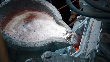 Ladle with molten metal is poured into a mold