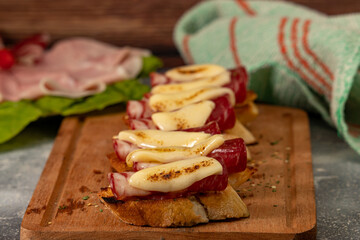 Tables of cold cuts - hams, bondiola -, cheeses and bruschetta tapas, Iberian ham and mozzarella.
