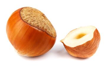 The solid hazelnut and half of the hazelnut core are isolated on a white background.