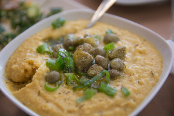 A bowl of traditional Greek Fava - Puree of Yellow split peas, served with Capers and scallion 