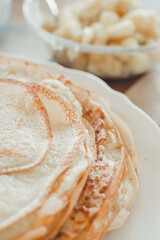Pancake baking process. Ready-made pancakes on a white plate.
