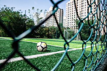 Football in a football field separated by barbed wire