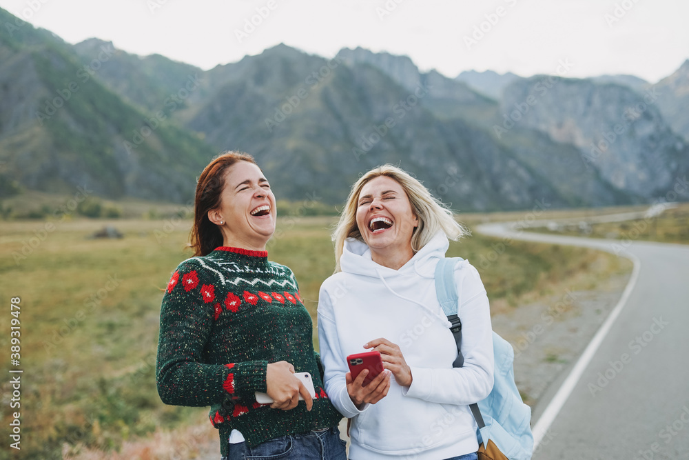 Canvas Prints happy young women travellers using mobile on road against the beautiful mountain landscape - Canvas Prints