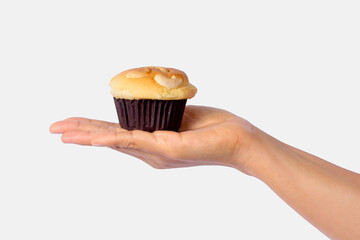 Female hand holding cupcake isolated on white background