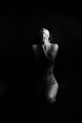 	 black and white portrait of a young girl on a dark background in the Studio