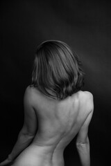 	 black and white portrait of a young girl on a dark background in the Studio