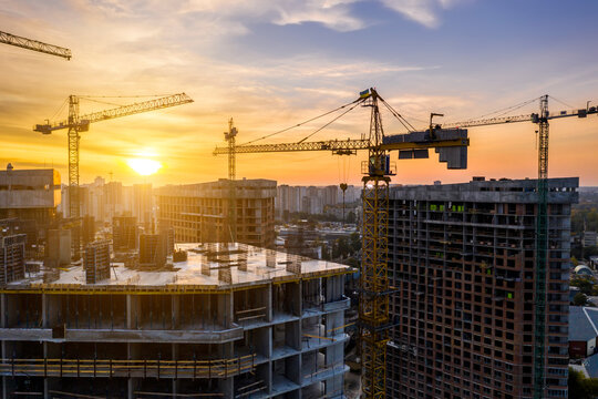 Construction site with cranes at sunset. Construction of an apartment building