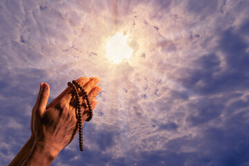 Man hand with beads praying god.