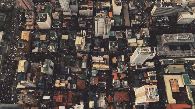 Top down of skyscrapers roofs aerial. Manila metropolis city architecture at downtown streets. Majestic cityscape of Philippines capital town. Traffic roads with cars at block houses, cottages