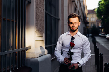 Man with rose. Brutal man with beard and red rose.