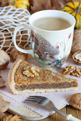 Stück von Walnuss-Tarte und Kaffeetasse auf Holzbrett