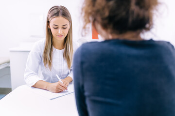 doctor writing a prescription medicine to a patient