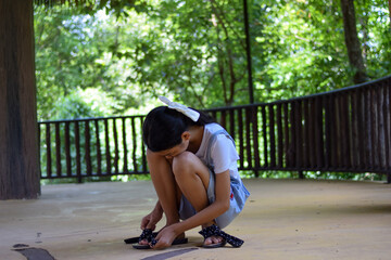 a girl sitting and Tie shoelaces