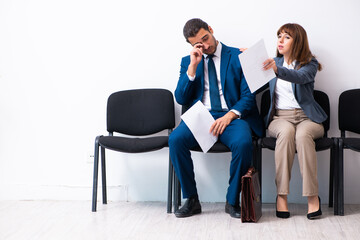 Young businessman and businesswoman waiting for an interview at