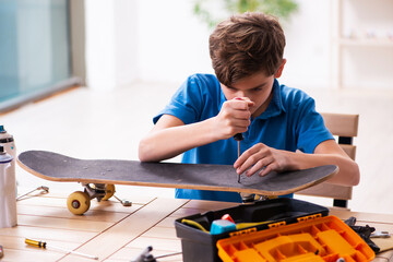 Boy reparing skateboard at home