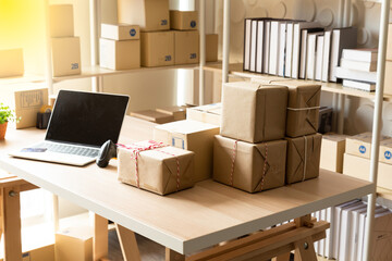 Online shopping office or Home office with computer laptop and barcode scanner on the product's desk with brown boxes on the table, Start up small business entrepreneur E-commerce concept.