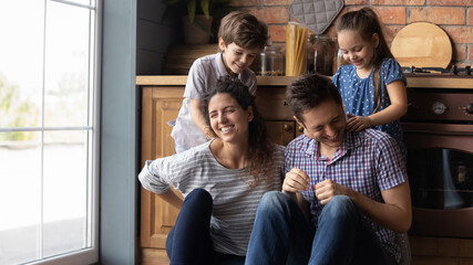 Wide banner web panoramic view of happy little kids have fun with smiling young Caucasian parents...