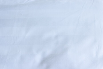 Top view of white fabric bed sheet with pillowcases texture background.