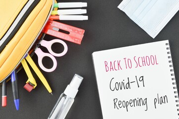 Back to school COVID-19 reopening plan, flat lay arrangement of school supplies and personal protective equipment. Education concept due to Coronavirus COVID-19 pendemic.