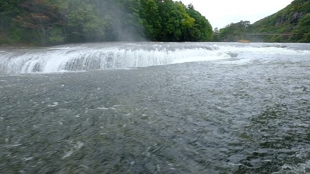 The enormous Fukiware Falls is often called "Japan's version of Niagara Falls", - a gigantic water stream that flows noisily in a rocky environment next to Numata, near Nikko National Park, Japan.