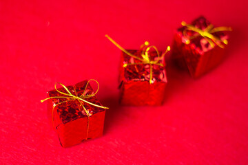 Christmas decorations on a red background. Holiday decorations. Three red gifts on a red background. Christmas concept