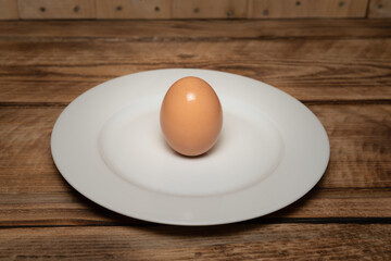 Egg on white plate, healthy nutritional meal. Isolated on a woodgrain background. Protein packed snack.