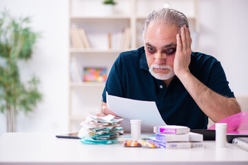 Old injured man in budget planning concept