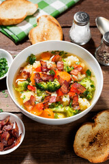 Soup with broccoli and cauliflower served with smoked bacon and toasted bread.