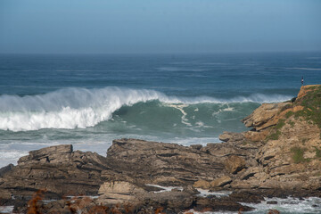 Fototapeta na wymiar ola grande rompiendo en una costa de rocas 