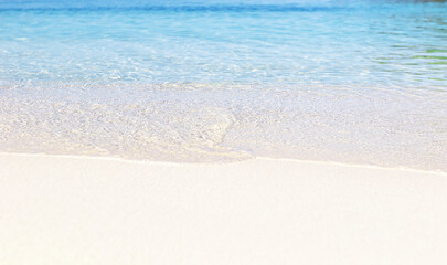 Close up photo of crystal clear water and sand on beach of Ksamil in Albania