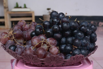 grapes and longans on a plate on a white background