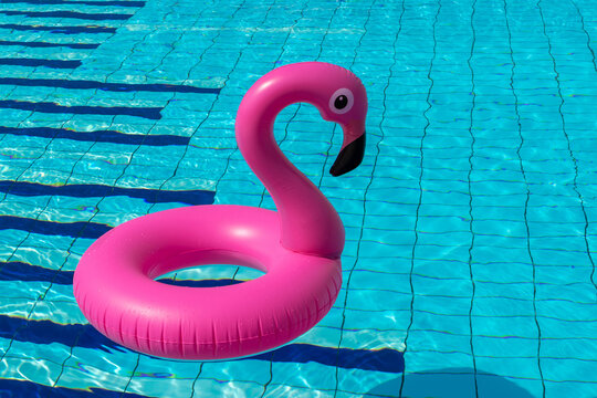 Summer sale. Pink inflatable flamingo in pool water for summer beach background. Minimal summer concept.