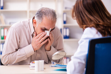Old man visiting young female doctor for plastic surgery