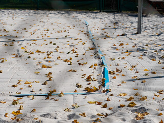 Closed beach volleyball court in fall season. Fallen leaves on closed beach volleyball playground